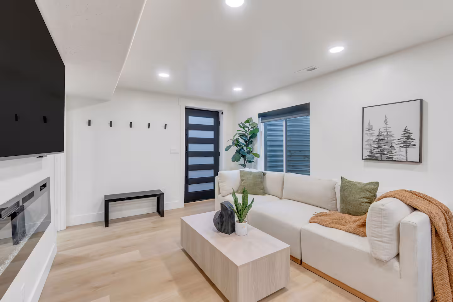 Modern living room with a 3-piece sectional accompanied by a mud room to hang coats and store shoes