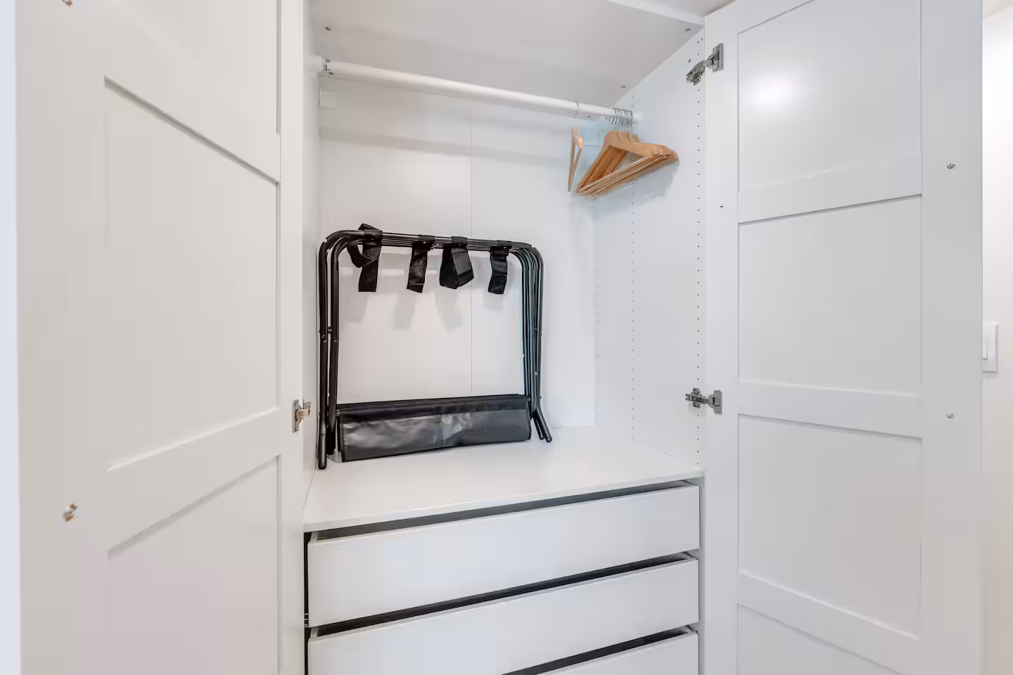 Hangars and luggage rack inside of closet